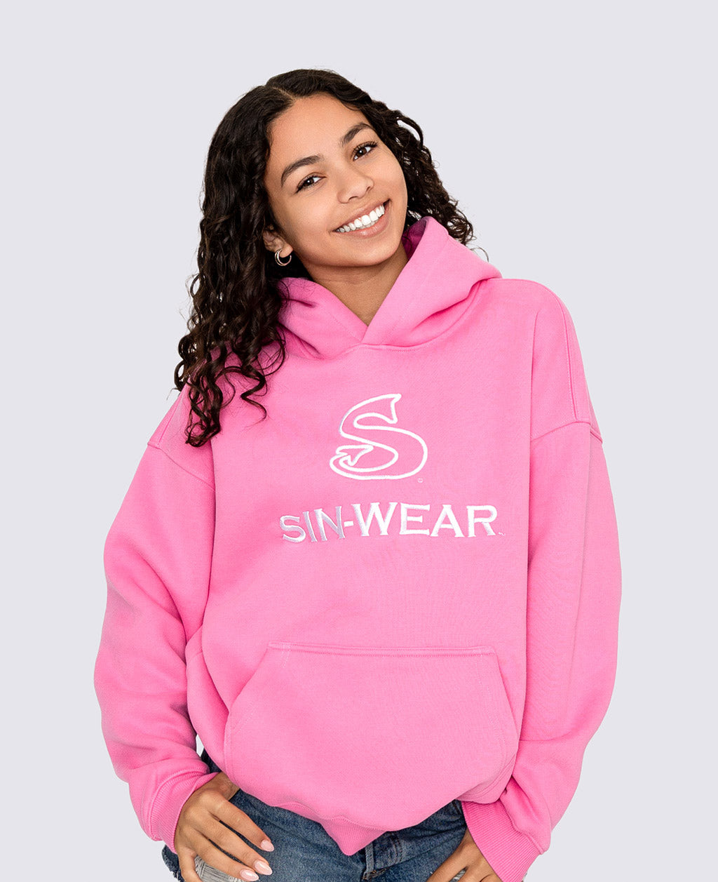 Person wearing a pink hoodie with 'SIN-WEAR' logo on a light gray background