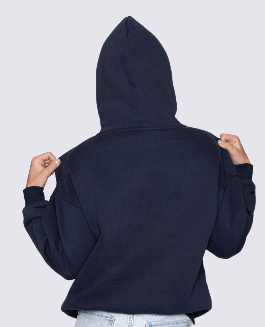 Person wearing a navy blue hoodie with the hood up on a light gray background