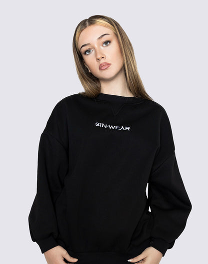 Person wearing a black sweatshirt with 'SIN-WEAR' logo on a light gray background