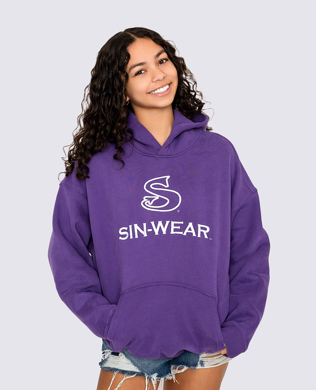 Person wearing a purple hoodie with 'SIN-WEAR' logo on a light gray background