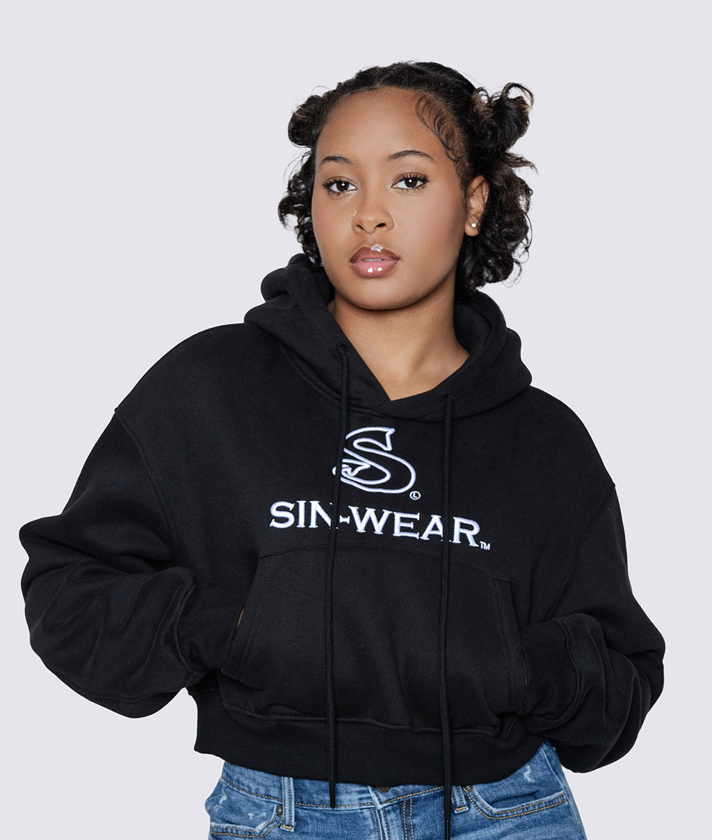 Person wearing a black crop hoodie with 'Sin-Wear' logo on a white background