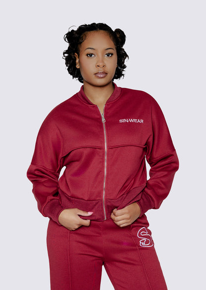 Woman wearing a dark red tracksuit with 'Sin-Wear' branding on a white background