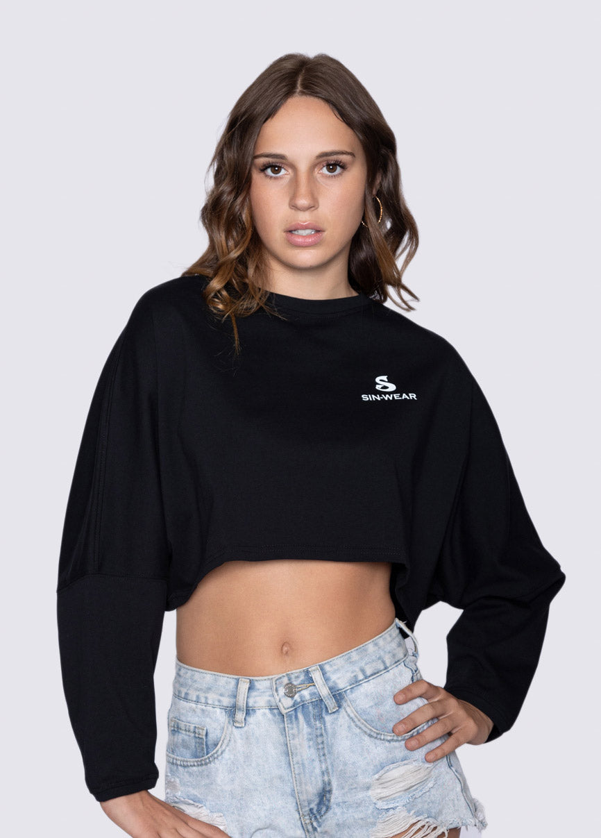 Woman wearing a black cropped sweatshirt with Sin-Wear logo on a plain background