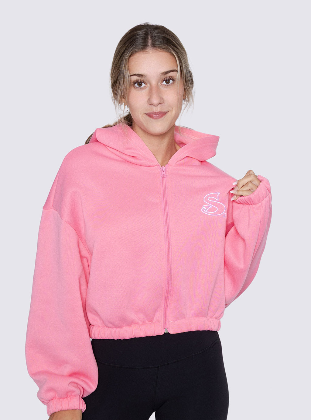 Person wearing a pink crop zip hoodie with 'Sin-Wear' logo on a light gray background