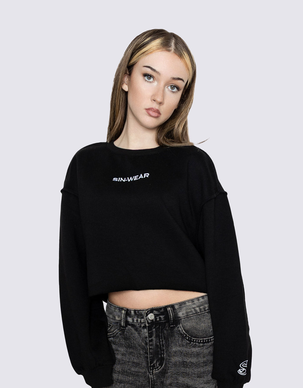 Person wearing a black crop top with 'Sin-Wear' branding on a plain background