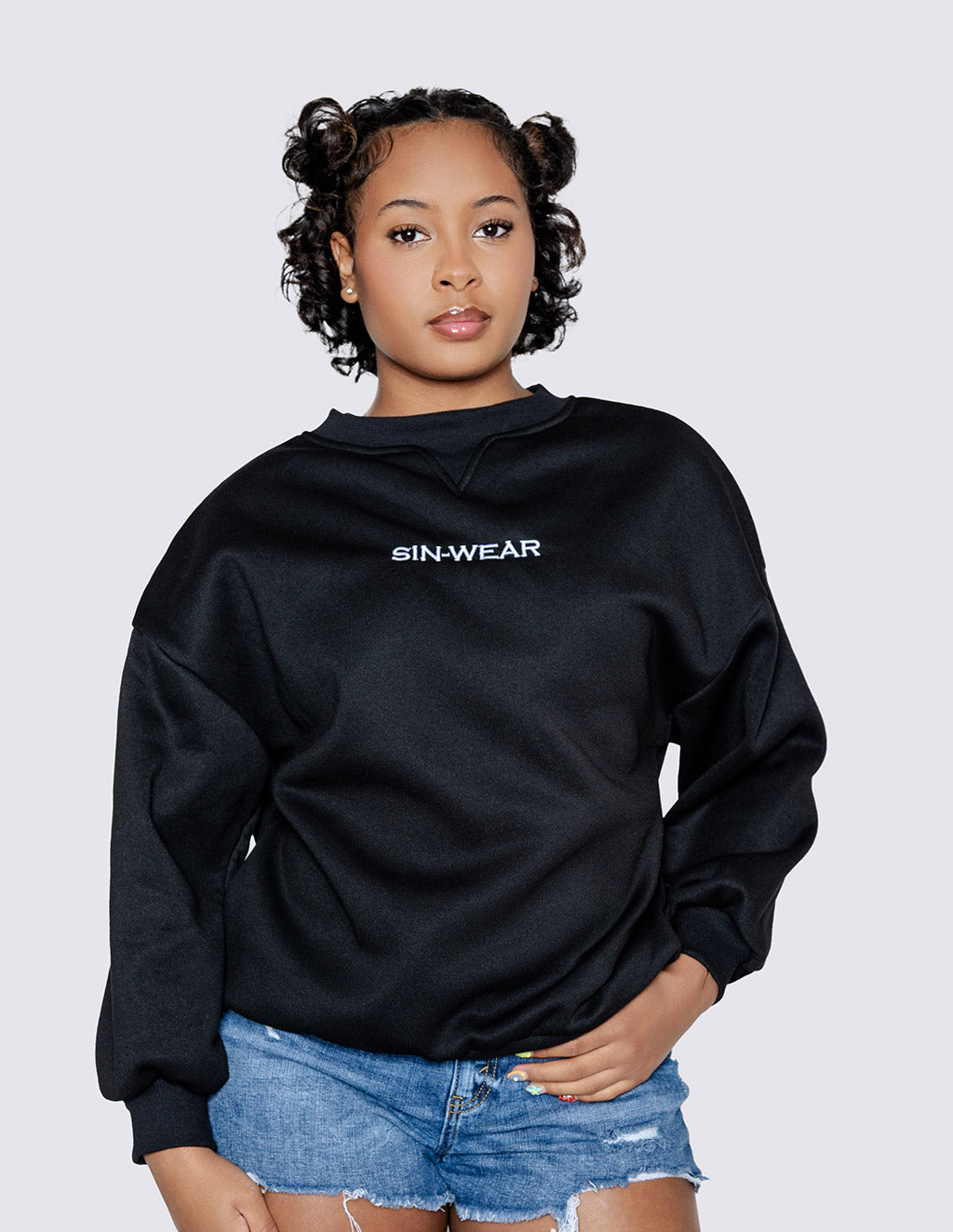 Person wearing a black hoodie with 'Sin-Wear' logo on a light gray background