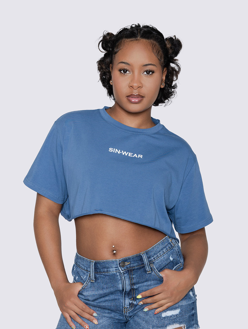 Person wearing a blue crop top with 'SIN-WEAR' branding on a plain background