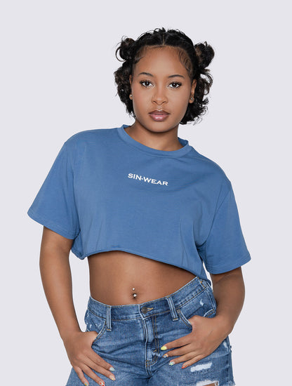 Person wearing a blue crop top with 'SIN-WEAR' branding on a plain background