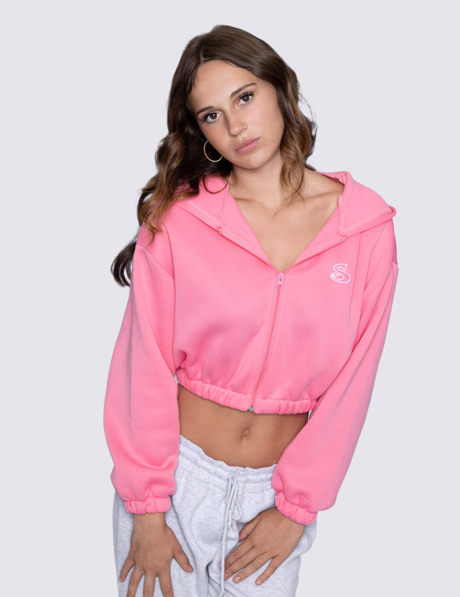 Woman wearing a pink cropped zipper hoodie with 'Sin-Wear' logo on a white background
