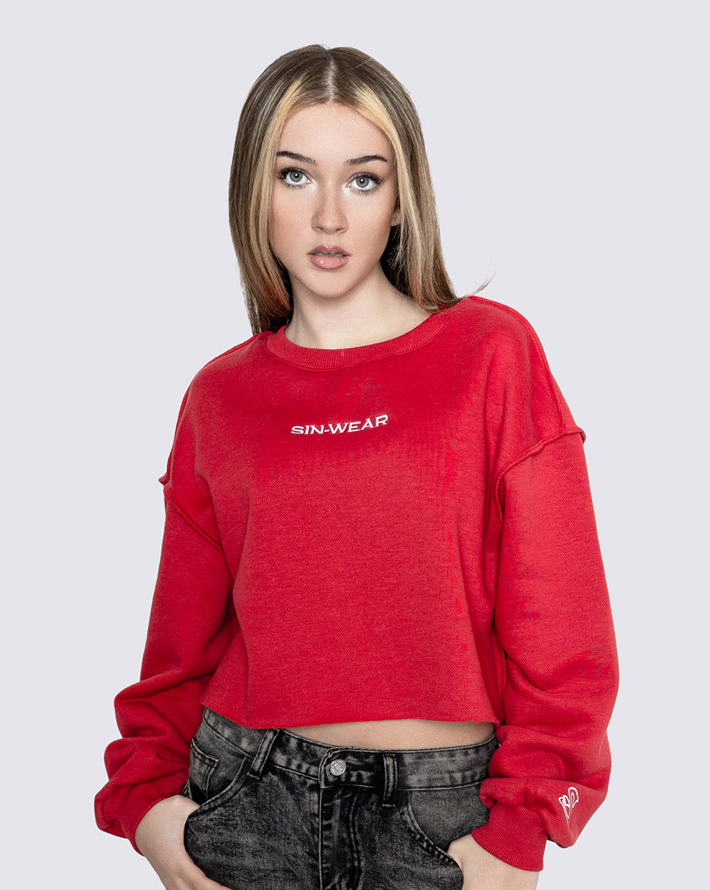 Person wearing a red crop sweatshirt with 'Sin-Wear' logo on a white background