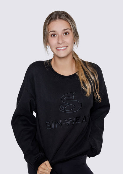 Woman wearing a black sweatshirt with 'SIN-WEAR' branding on a white background