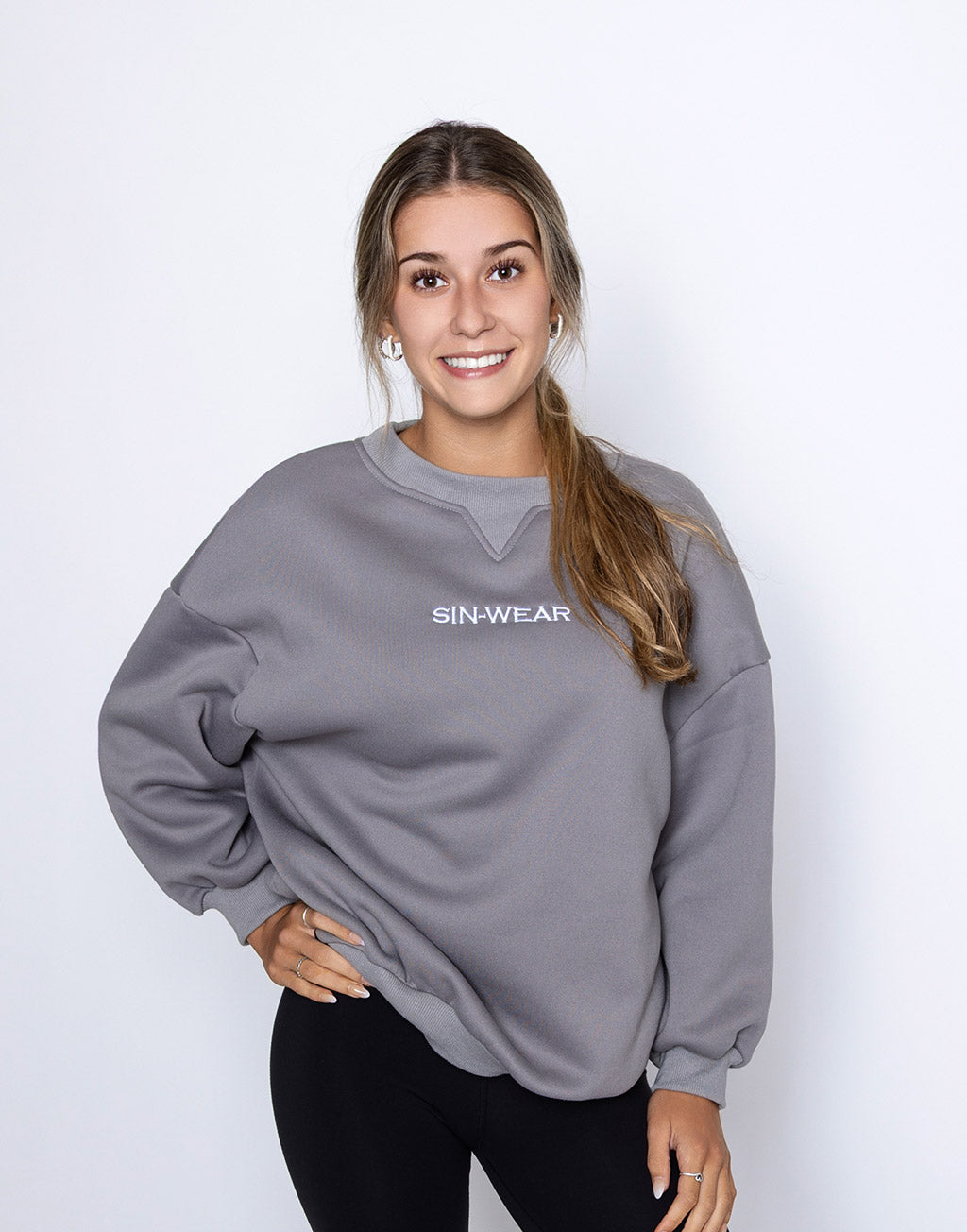 Person wearing a gray sweatshirt with 'SIN-WEAR' logo on a white background