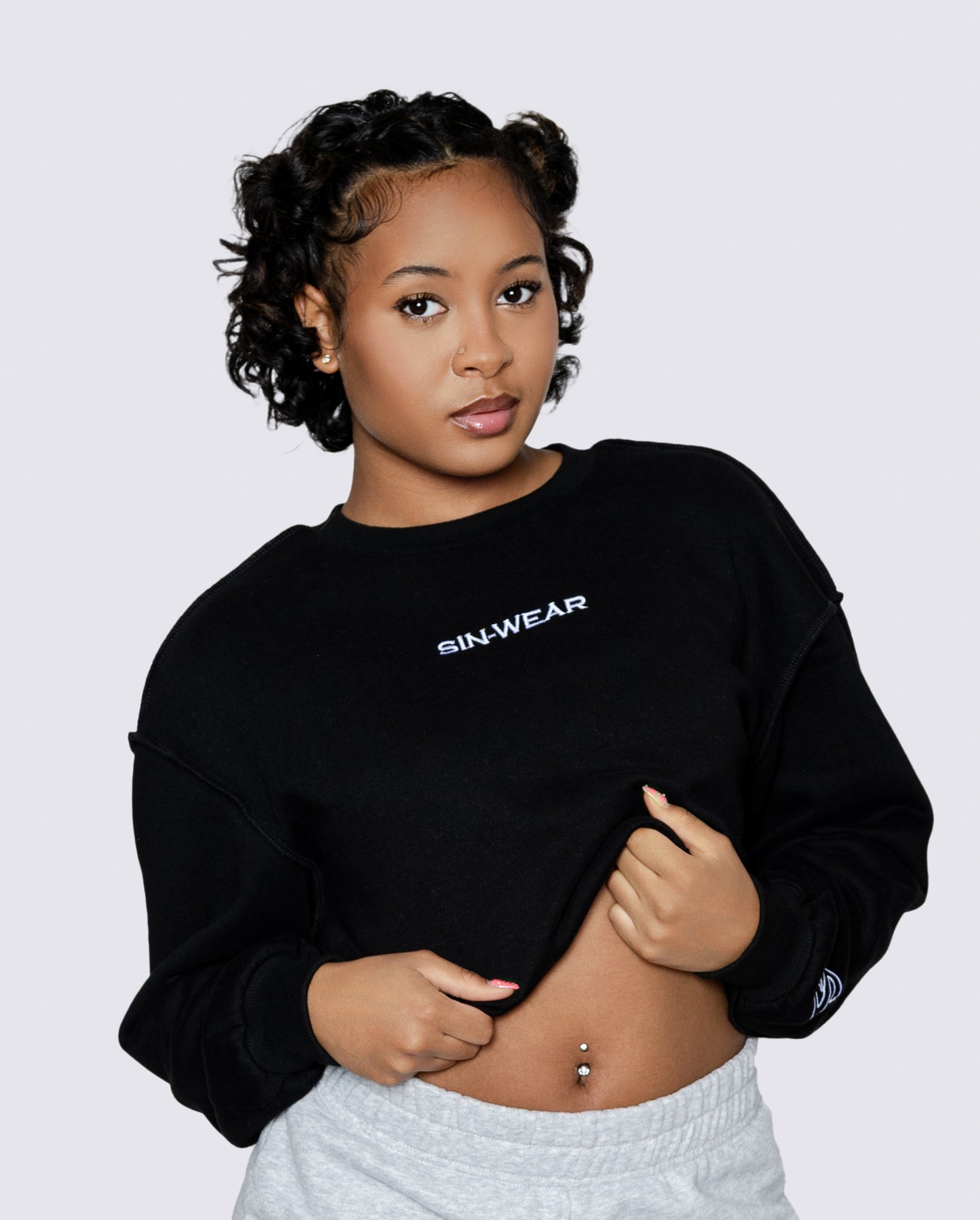 Person wearing a black sweatshirt with 'Sin-Wear' branding on a light gray background