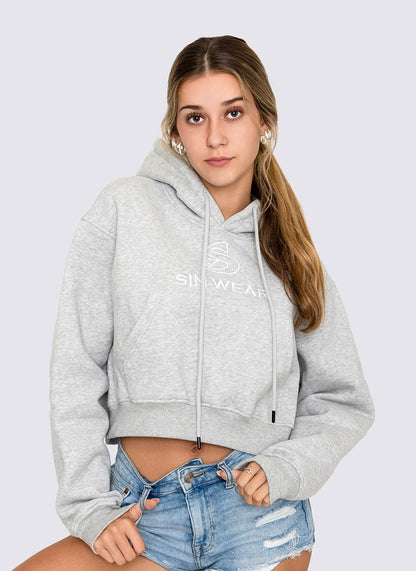 Woman wearing a gray crop hoodie with 'Sin-Wear' branding on a light gray background