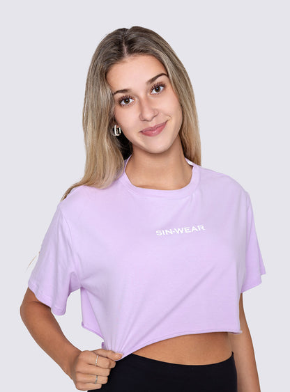 Woman wearing a light purple t-shirt with 'SIN-WEAR' logo on a plain background