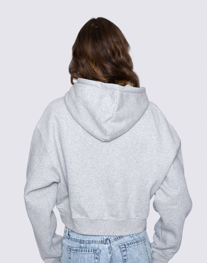 Person wearing a gray hoodie from behind on a light gray background