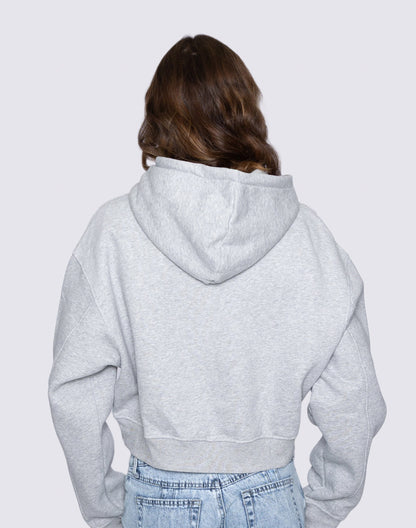 Person wearing a gray hoodie from behind on a light gray background