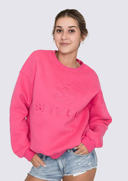Person wearing a pink sweatshirt with 'SIN-WEAR' text on a plain background